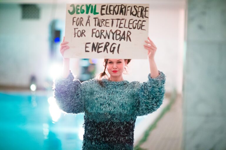 Modell med plakat: Jeg vil elektrifisere for å tilrettelegge for fornybar energi.